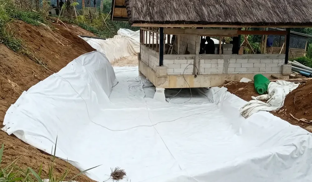 Pemasangan geotextile non woven sebagai pelindung geomembran yang akan dipasang diatasnya