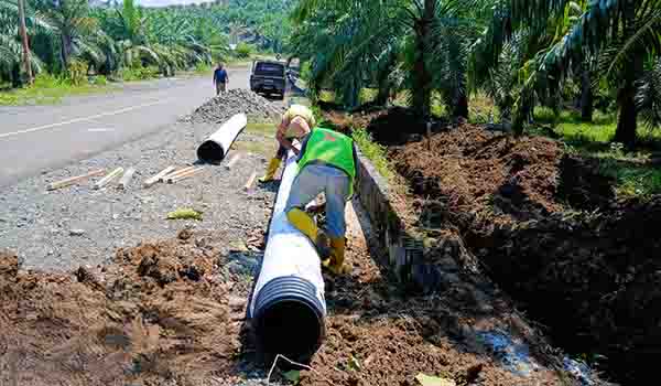 proses pemasangan drainase permukaan (surface drainage) untuk selokan